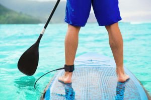 Paddle board man doing stand-up paddleboard on ocean